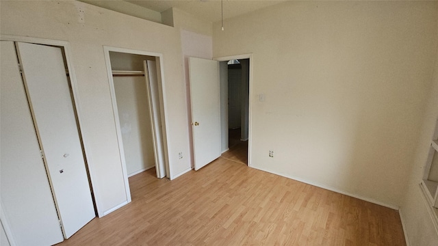 741 Cardinal Dr, Saginaw, TX 76131 - unfurnished bedroom featuring light wood-style flooring, baseboards, and two closets