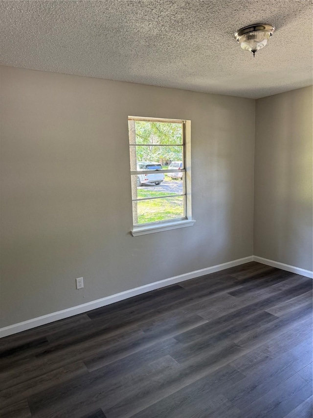 405 Forest Ln, Gun Barrel City, TX 75156 - empty room featuring dark wood-type flooring, baseboards, and a textured ceiling