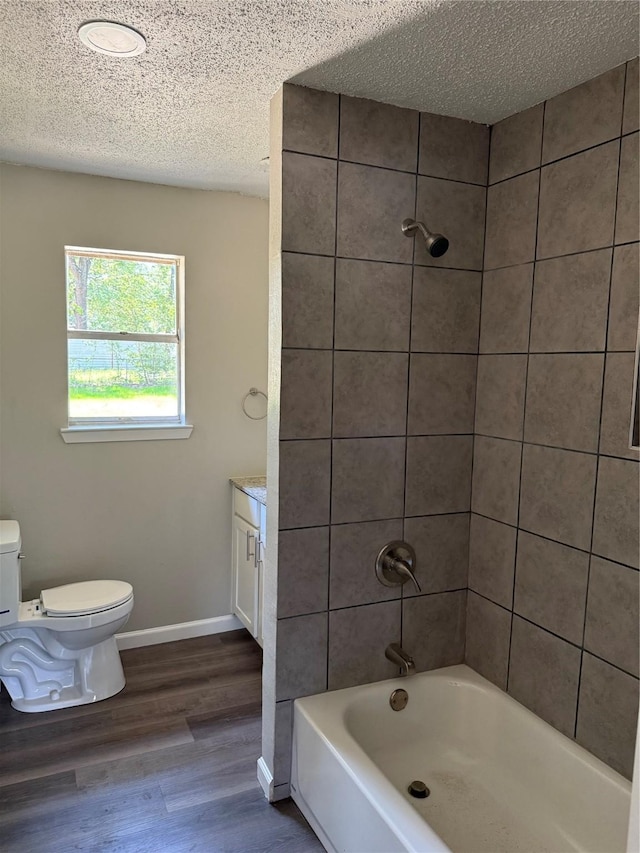 405 Forest Ln, Gun Barrel City, TX 75156 - bathroom with toilet, tub / shower combination, wood finished floors, baseboards, and a textured ceiling