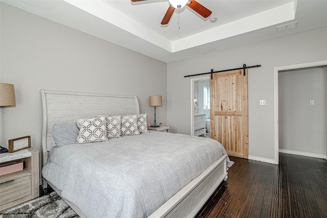 2420 Poplar Spring Rd, Fort Worth, TX 76123 - bedroom featuring a barn door, hardwood / wood-style floors, baseboards, ceiling fan, and ensuite bathroom