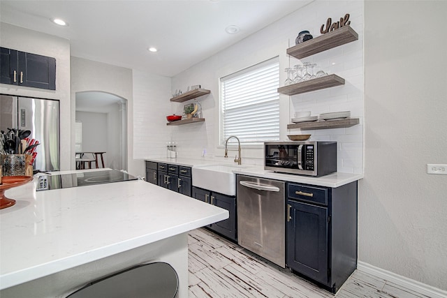 2420 Poplar Spring Rd, Fort Worth, TX 76123 - kitchen featuring open shelves, appliances with stainless steel finishes, a sink, arched walkways, and tasteful backsplash