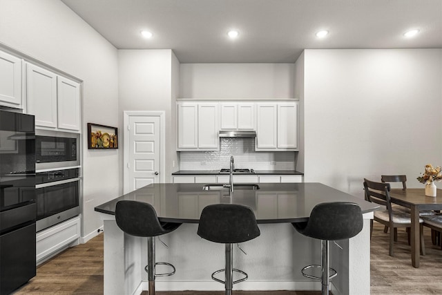 1714 Lone Lynx Way, Wylie, TX 75098 - kitchen with stainless steel appliances, dark countertops, decorative backsplash, a breakfast bar, and recessed lighting