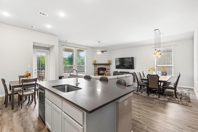 1714 Lone Lynx Way, Wylie, TX 75098 - kitchen with a sink, a stone fireplace, dark countertops, wood finished floors, and recessed lighting