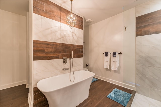 2025 Columbus Ave, Waco, TX 76701 - full bath with a freestanding tub, wood finished floors, a chandelier, and baseboards