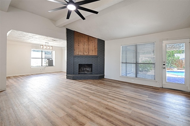 3229 Poteet Dr, Mesquite, TX 75150 - unfurnished living room featuring light wood finished floors, a fireplace, a ceiling fan, and a chandelier