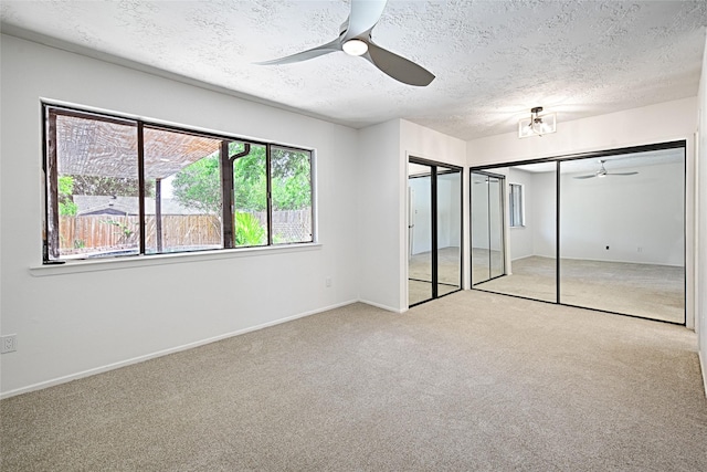 3229 Poteet Dr, Mesquite, TX 75150 - unfurnished bedroom with carpet, a textured ceiling, baseboards, a ceiling fan, and multiple closets