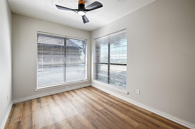 3229 Poteet Dr, Mesquite, TX 75150 - empty room featuring wood finished floors, plenty of natural light, ceiling fan, and a textured ceiling