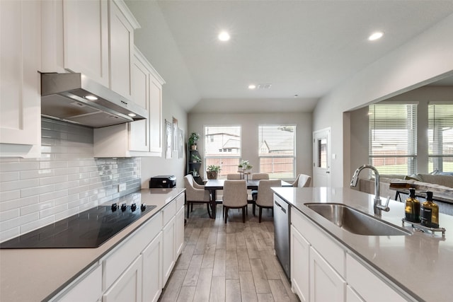 6005 Loving Ct, Midlothian, TX 76065 - kitchen featuring black electric stovetop, a sink, wall chimney exhaust hood, light wood-style floors, and recessed lighting