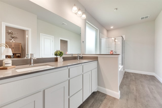 6005 Loving Ct, Midlothian, TX 76065 - full bathroom featuring a shower with shower door, wood finished floors, double vanity, and baseboards