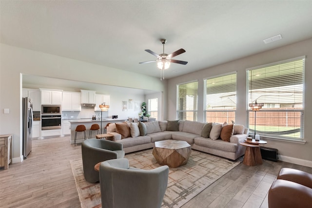 6005 Loving Ct, Midlothian, TX 76065 - living room with light wood-style floors, healthy amount of natural light, a ceiling fan, and baseboards