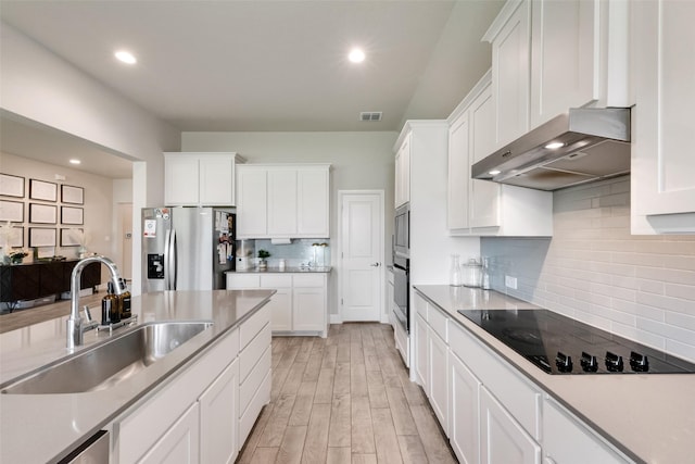 6005 Loving Ct, Midlothian, TX 76065 - kitchen featuring appliances with stainless steel finishes, a sink, wall chimney exhaust hood, tasteful backsplash, and white cabinetry