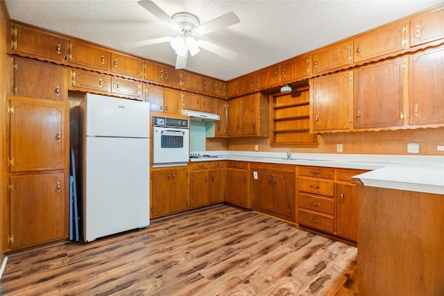 1019 E Elm St, Hillsboro, TX 76645 - kitchen featuring white appliances, brown cabinets, and a textured ceiling