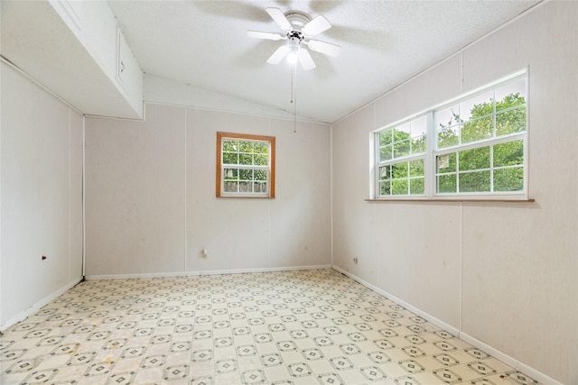 1019 E Elm St, Hillsboro, TX 76645 - unfurnished room featuring light flooring, vaulted ceiling, a ceiling fan, a textured ceiling, and baseboards