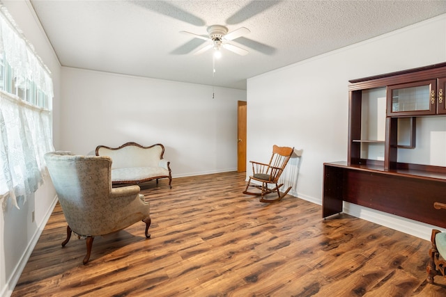 1019 E Elm St, Hillsboro, TX 76645 - sitting room with wood finished floors, ceiling fan, baseboards, and a textured ceiling