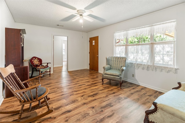 1019 E Elm St, Hillsboro, TX 76645 - living area featuring wood finished floors, a textured ceiling, ceiling fan, and baseboards