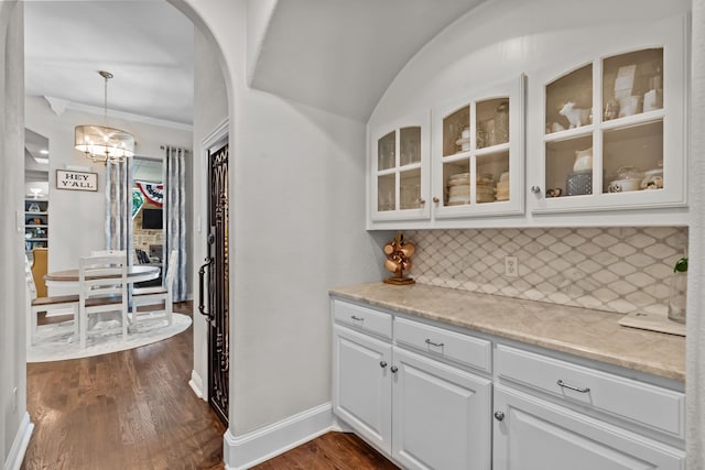 1809 Summit Ct, Keller, TX 76262 - bar featuring tasteful backsplash, dark wood finished floors, arched walkways, a chandelier, and baseboards