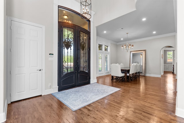 1809 Summit Ct, Keller, TX 76262 - entrance foyer with a chandelier, arched walkways, wood finished floors, crown molding, and french doors