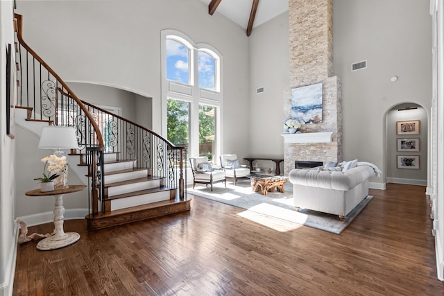 1809 Summit Ct, Keller, TX 76262 - living area featuring high vaulted ceiling, arched walkways, wood finished floors, a stone fireplace, and stairs