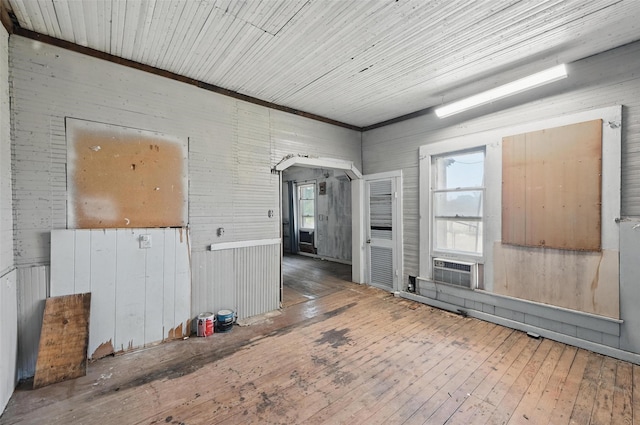 402 S Watson St, Alvarado, TX 76009 - spare room featuring wood-type flooring, healthy amount of natural light, wooden walls, and arched walkways
