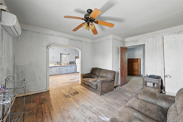 402 S Watson St, Alvarado, TX 76009 - living room with a wall unit AC, hardwood / wood-style floors, a ceiling fan, and arched walkways