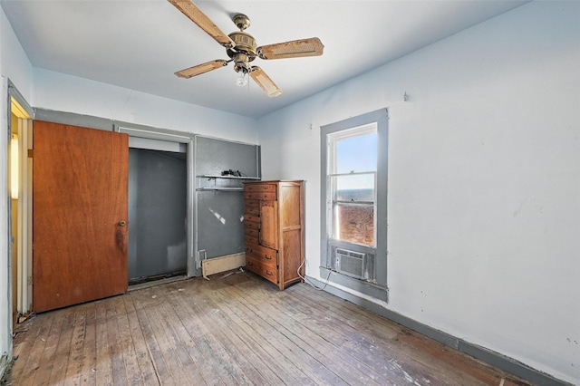 402 S Watson St, Alvarado, TX 76009 - unfurnished bedroom featuring wood-type flooring, cooling unit, a closet, baseboards, and a ceiling fan