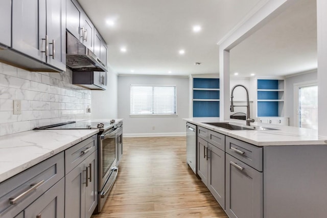 2638 Custer Pkwy Unit B, Richardson, TX 75080 - kitchen featuring gray cabinets, stainless steel appliances, a sink, under cabinet range hood, and light wood-type flooring