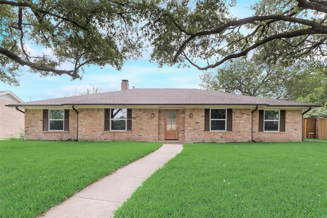 single story home with a chimney, brick siding, and roof with shingles