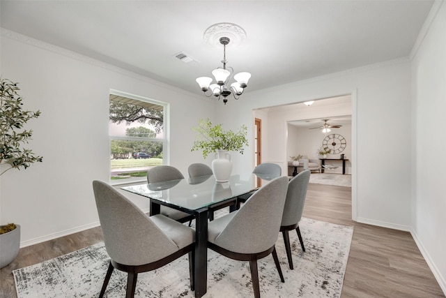 dining area with a chandelier, crown molding, light wood finished floors, and baseboards
