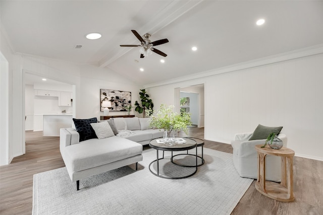 living area with a ceiling fan, light wood-type flooring, ornamental molding, and baseboards