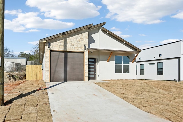 3613 Durango Trl, Granbury, TX 76048 - view of front of house featuring concrete driveway, an attached garage, stone siding, stucco siding, and fence