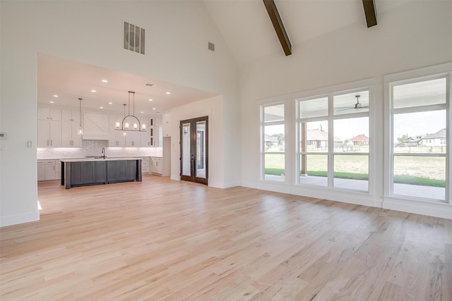 138 Buddy Ct, Millsap, TX 76066 - unfurnished living room featuring a sink, a chandelier, light wood-style flooring, beam ceiling, and high vaulted ceiling