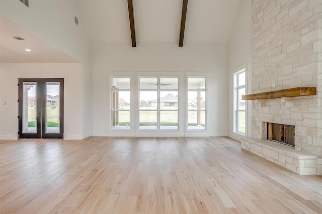138 Buddy Ct, Millsap, TX 76066 - unfurnished living room featuring high vaulted ceiling, a stone fireplace, light wood-type flooring, baseboards, and french doors