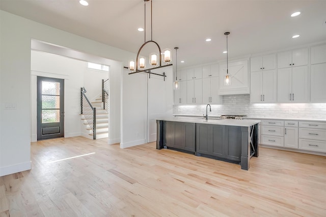 138 Buddy Ct, Millsap, TX 76066 - kitchen with a sink, white cabinets, light countertops, decorative backsplash, and light wood finished floors