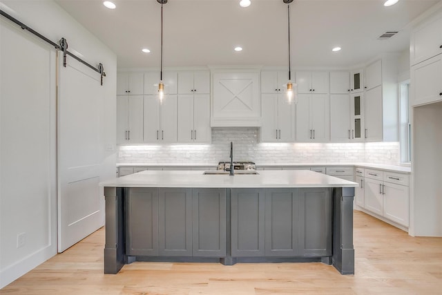 138 Buddy Ct, Millsap, TX 76066 - kitchen featuring a sink, white cabinetry, light countertops, a center island with sink, and backsplash