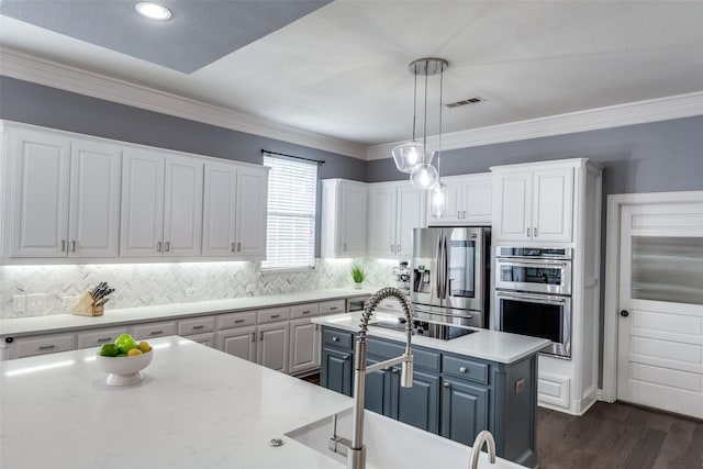 5060 Loma Alta Dr, Frisco, TX 75034 - kitchen featuring appliances with stainless steel finishes, white cabinets, a kitchen island, backsplash, and hanging light fixtures
