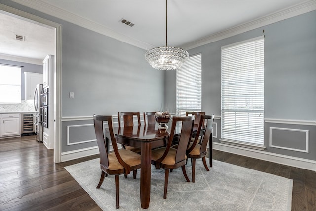 5060 Loma Alta Dr, Frisco, TX 75034 - dining area featuring wine cooler, a chandelier, crown molding, dark wood-style flooring, and a wainscoted wall
