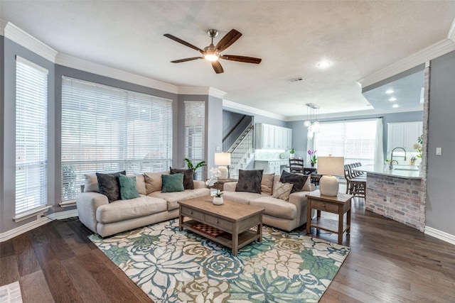 5060 Loma Alta Dr, Frisco, TX 75034 - living room with stairs, a ceiling fan, dark wood-style flooring, baseboards, and ornamental molding