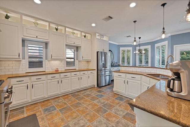 1123 Shadetree Ln, Allen, TX 75013 - kitchen featuring premium appliances, a sink, stone tile floors, white cabinetry, and ornamental molding