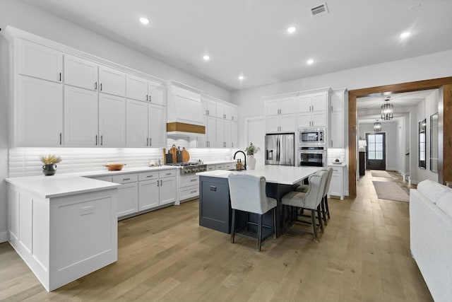 330 Peach Point Rd, Prosper, TX 75078 - kitchen featuring stainless steel appliances, white cabinetry, a kitchen breakfast bar, tasteful backsplash, and recessed lighting