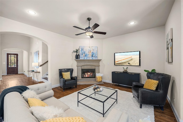 864 Gaited Trl, Frisco, TX 75036 - living room featuring arched walkways, a ceiling fan, wood finished floors, baseboards, and a glass covered fireplace