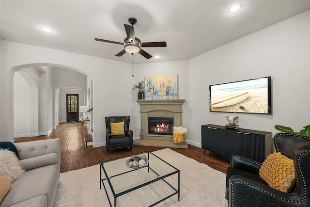 864 Gaited Trl, Frisco, TX 75036 - living area with ceiling fan, arched walkways, wood finished floors, a glass covered fireplace, and baseboards