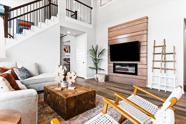 4342 Hudson St, Fate, TX 75087 - living room featuring wood finished floors, a glass covered fireplace, and stairs