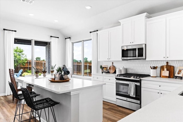 4342 Hudson St, Fate, TX 75087 - kitchen featuring stainless steel appliances, wood finished floors, light countertops, decorative backsplash, and vaulted ceiling