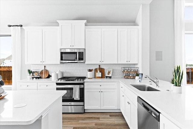 4342 Hudson St, Fate, TX 75087 - kitchen with appliances with stainless steel finishes, light countertops, backsplash, white cabinetry, and healthy amount of natural light