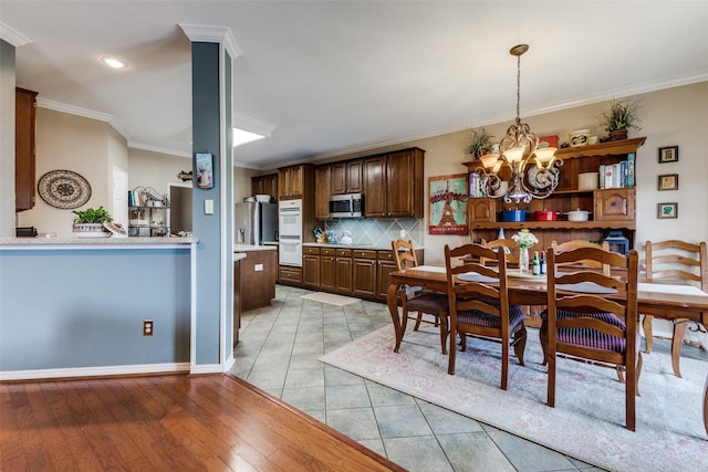 2420 Norwich Dr, Carrollton, TX 75006 - dining space featuring a chandelier, ornamental molding, baseboards, and light tile patterned floors