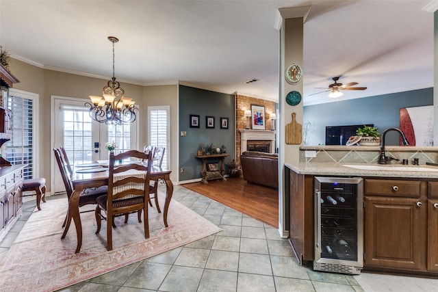 2420 Norwich Dr, Carrollton, TX 75006 - dining area with wine cooler, a chandelier, light tile patterned floors, ornamental molding, and ceiling fan