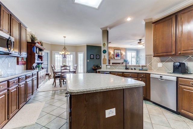 2420 Norwich Dr, Carrollton, TX 75006 - kitchen featuring appliances with stainless steel finishes, a sink, a center island, ornamental molding, and light tile patterned floors