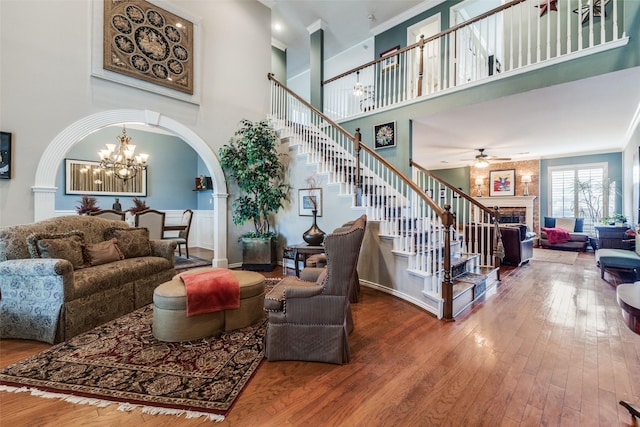 2420 Norwich Dr, Carrollton, TX 75006 - living area featuring arched walkways, a fireplace, a towering ceiling, stairway, and a chandelier