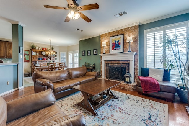 2420 Norwich Dr, Carrollton, TX 75006 - living area featuring wood finished floors, crown molding, a chandelier, a ceiling fan, and a fireplace
