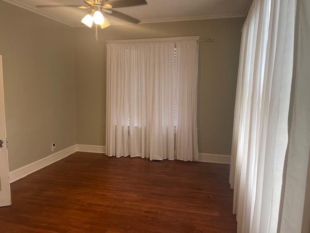 empty room with wood finished floors, a ceiling fan, baseboards, and crown molding